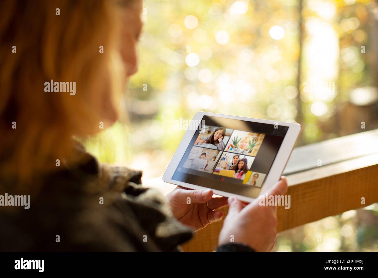 Woman video chatting with family on digital tablet screen Stock Photo
