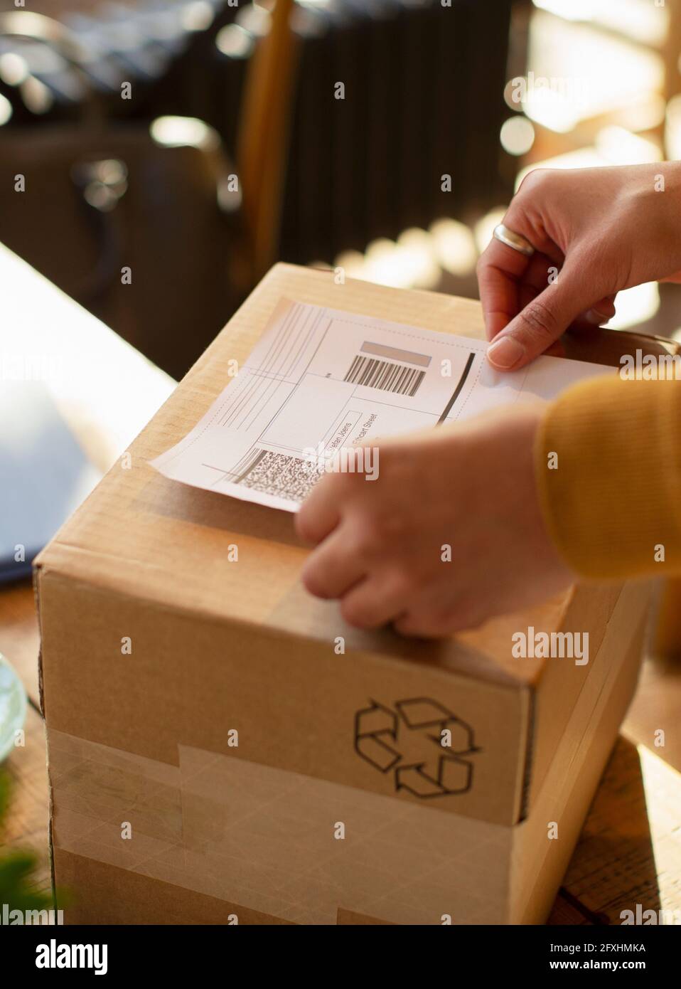 Close up business owner placing shipping label on box Stock Photo