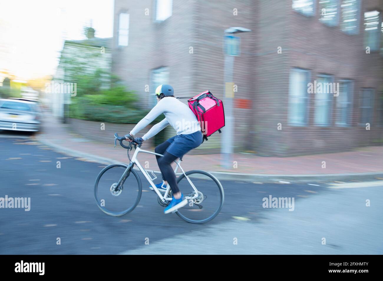 Male bike messenger delivering food on urban street Stock Photo