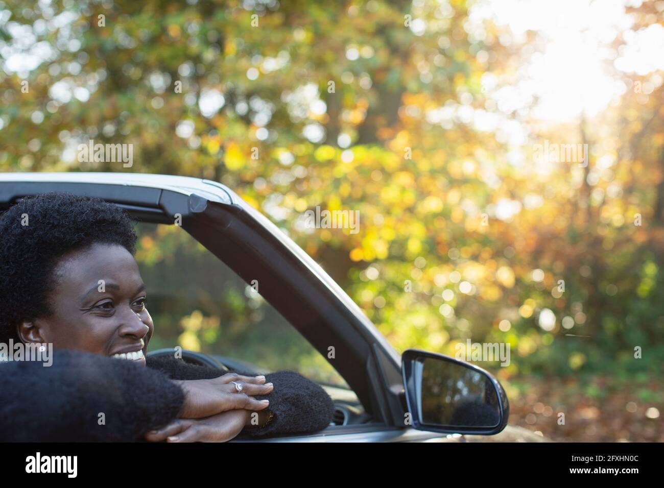 Happy woman in convertible in autumn park Stock Photo