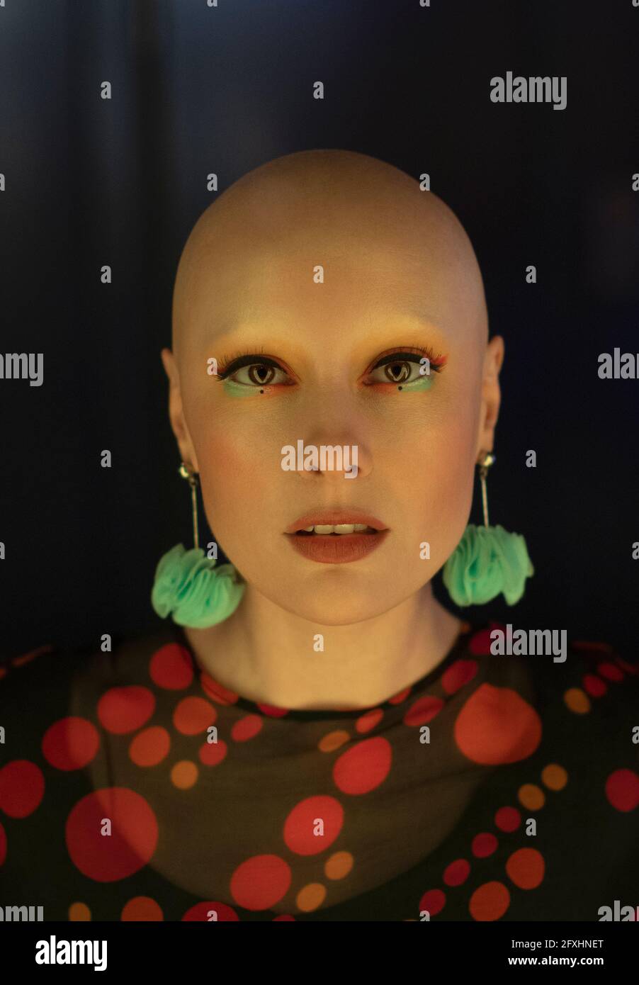 Close up portrait fashionable woman with shaved head and earrings Stock Photo