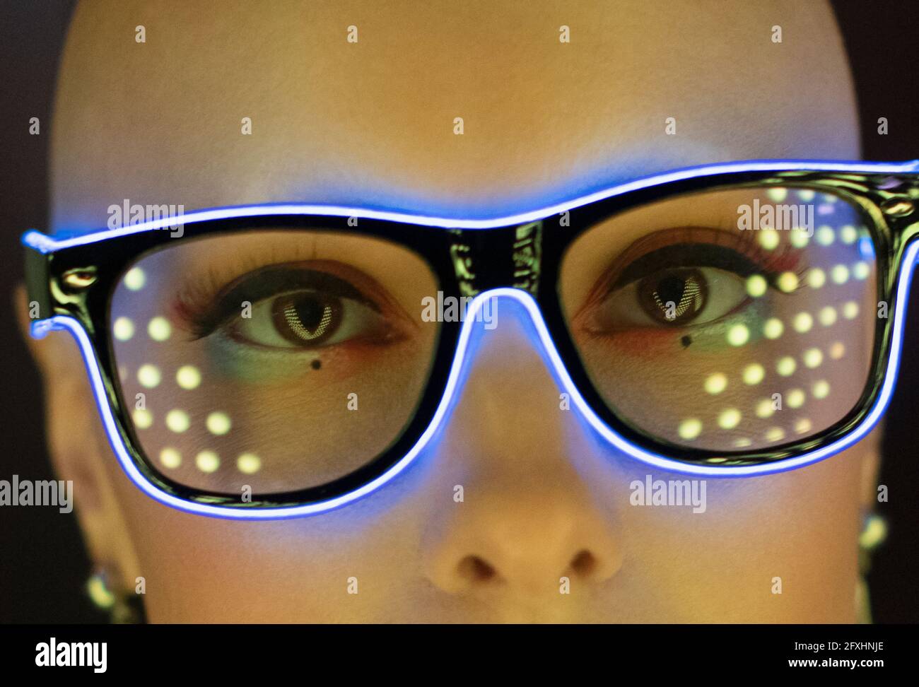 Close up portrait fashionable woman in futuristic neon eyeglasses Stock Photo