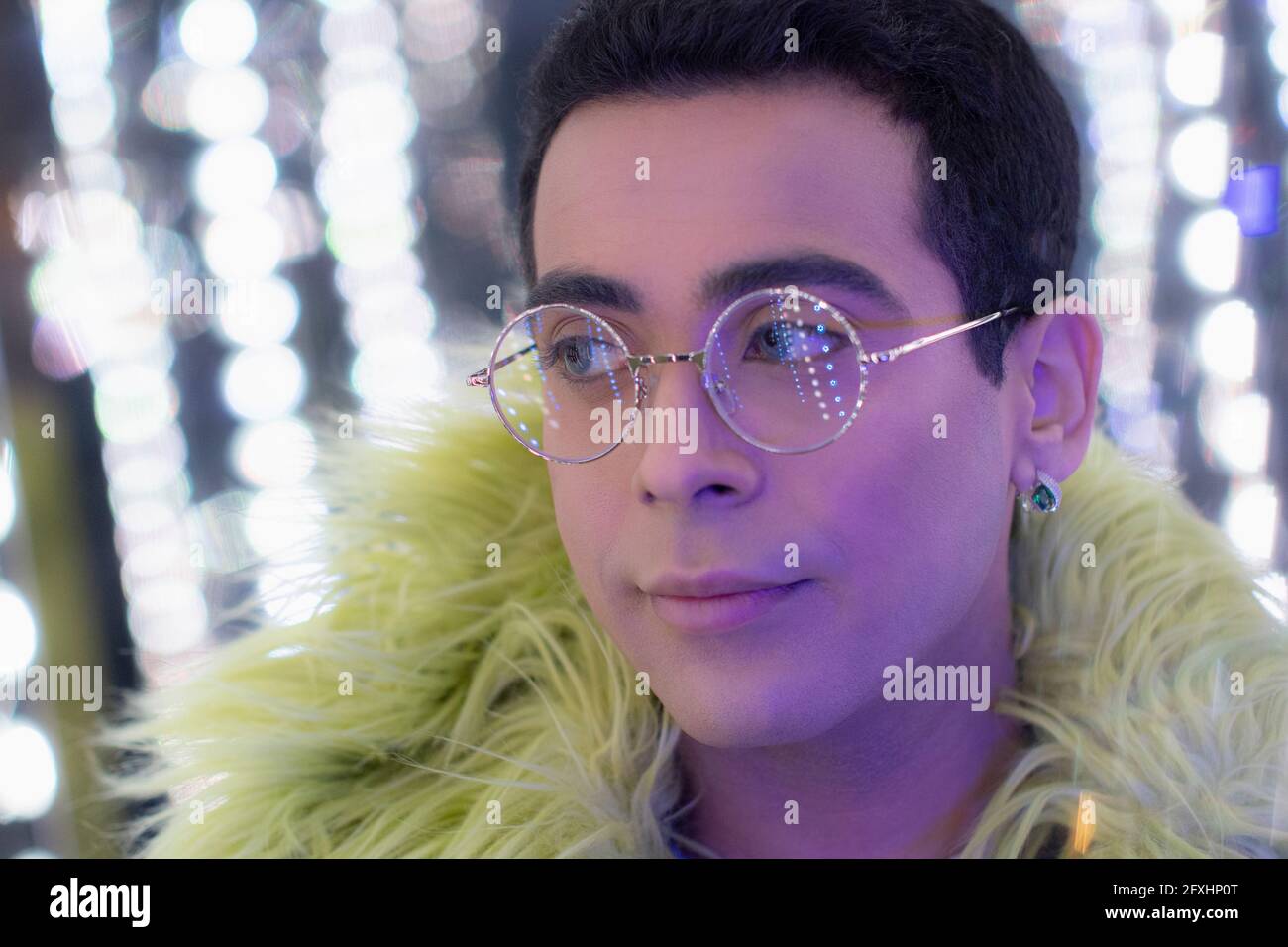 Close up portrait young man in feather boa and eyeglasses Stock Photo