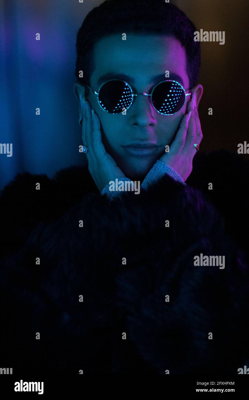 Portrait cool stylish young man wearing sunglasses in dark Stock Photo