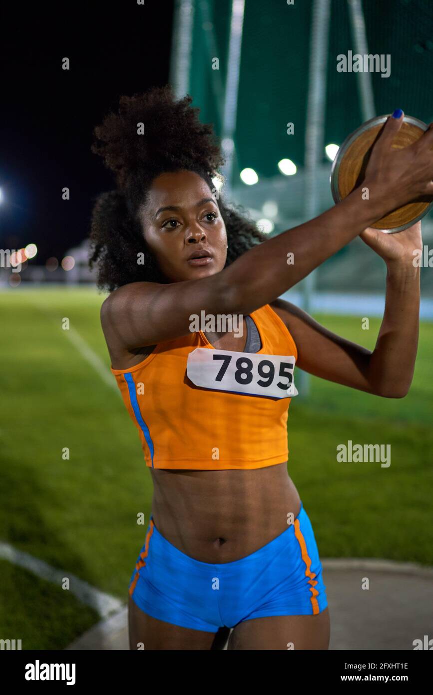Female track and field athlete throwing discus in competition Stock
