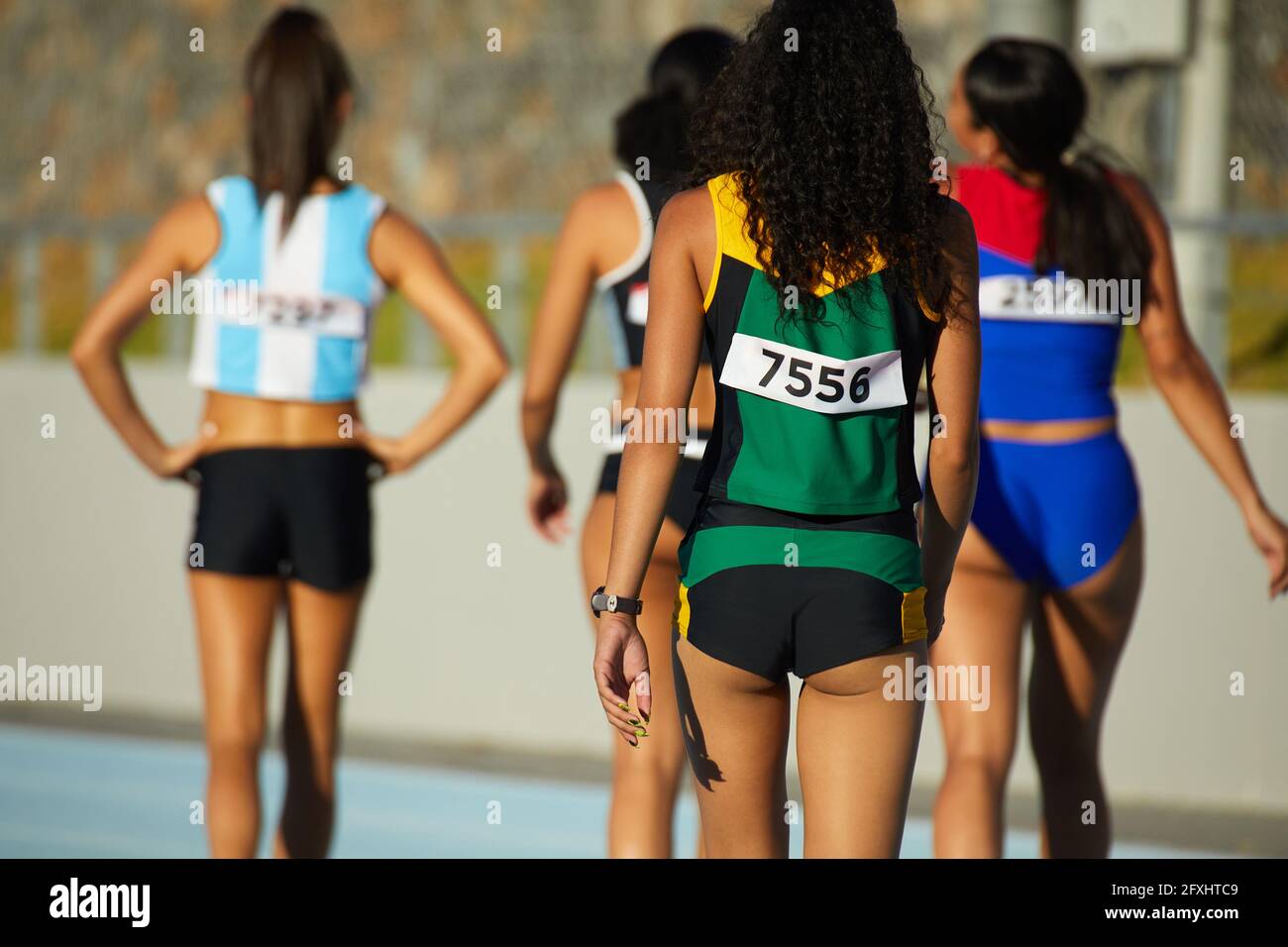 Female track and field athletes walking on sunny track Stock Photo Alamy