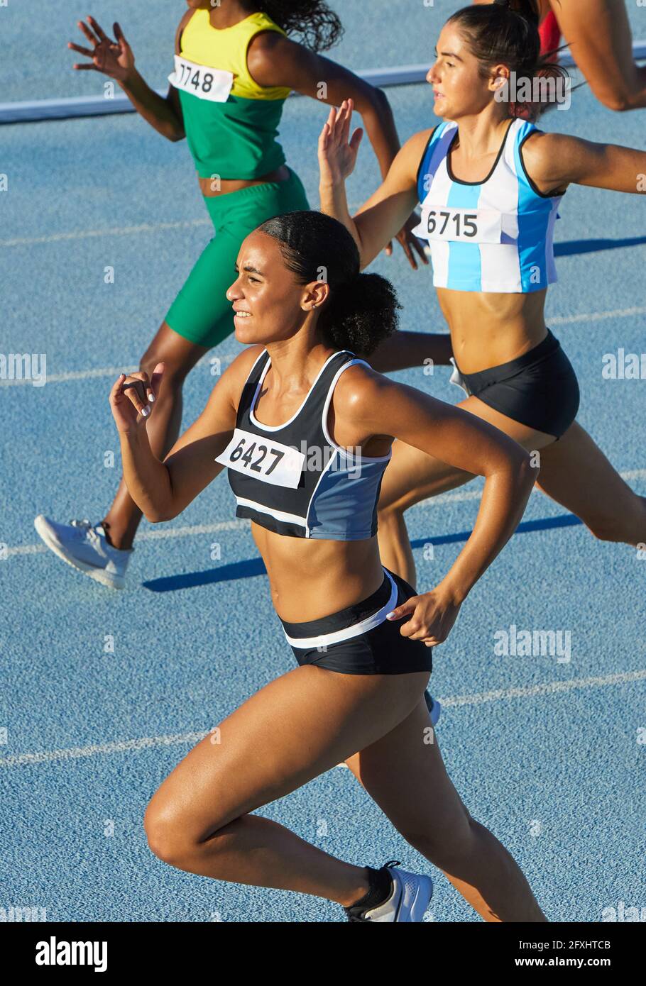 Female track and field athletes running on sunny track Stock Photo - Alamy