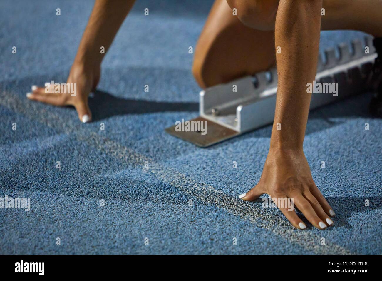 Close up female track and field athlete at starting block Stock Photo