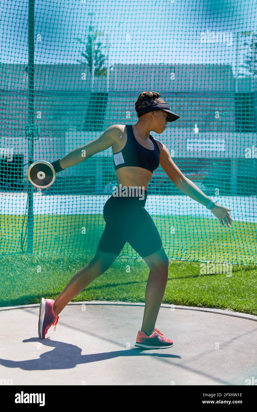 Female track and field athlete throwing discus Stock Photo