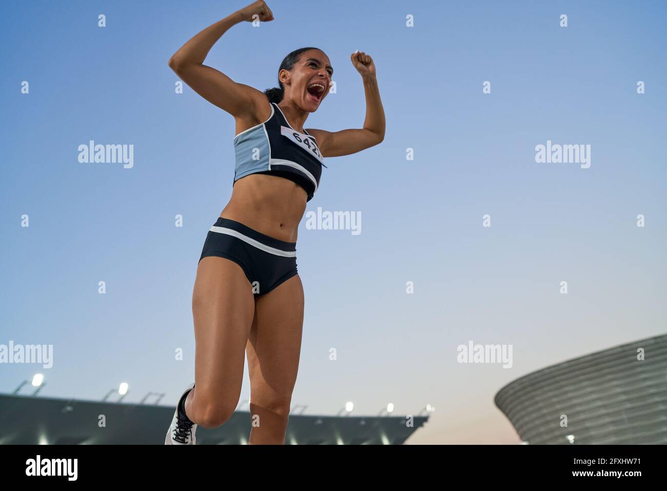 Excited track and field athlete celebrating victory Stock Photo