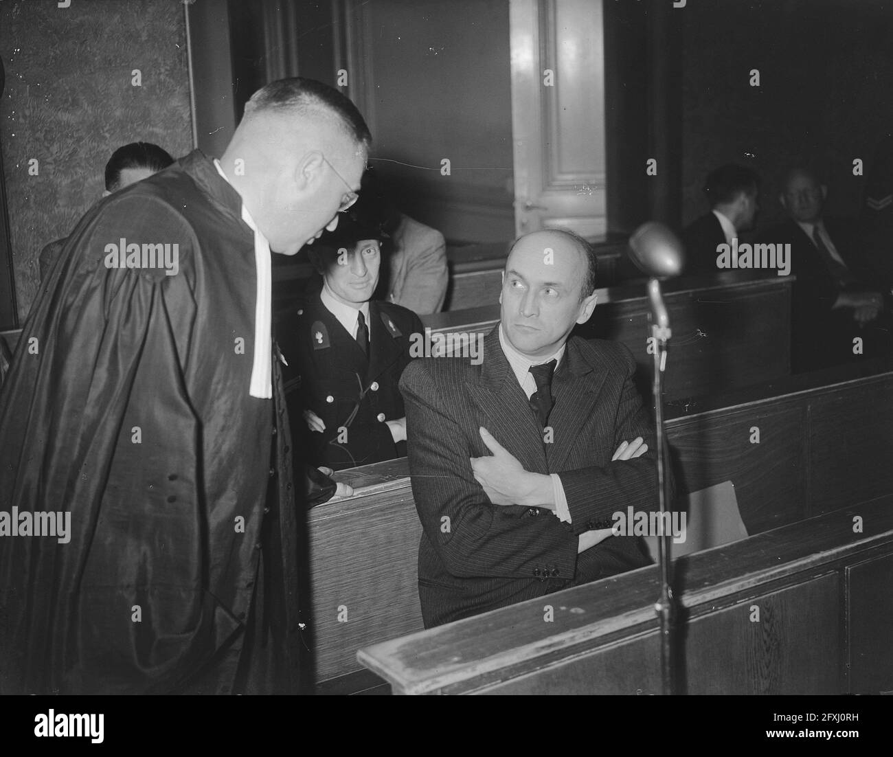 Willy Lages, former chief of the Amsterdam Sicherheitsdienst, during a hearing at the Special Court of Justice in Amsterdam. On the left his lawyer Mr. O.G. Veenstra, July 19, 1949, war criminals, lawsuits, second world war, The Netherlands, 20th century press agency photo, news to remember, documentary, historic photography 1945-1990, visual stories, human history of the Twentieth Century, capturing moments in time Stock Photo