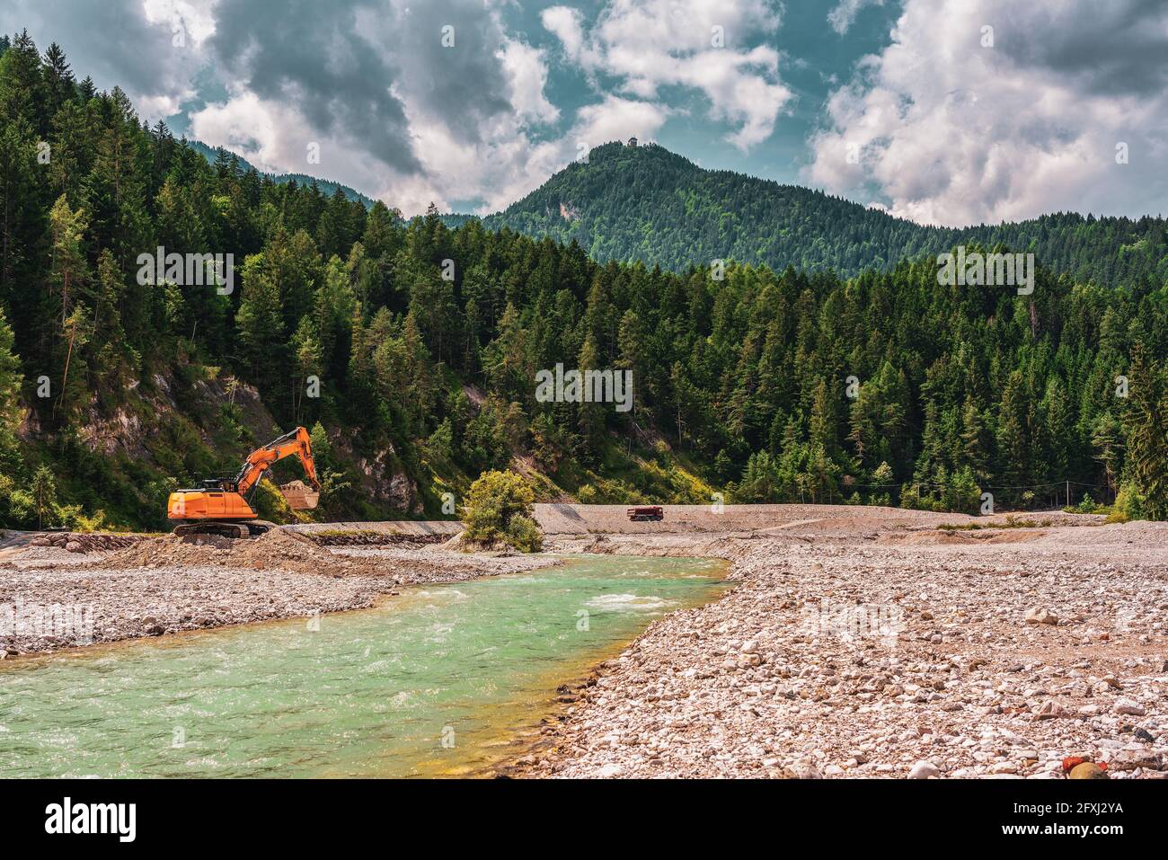 Excavator in the valley of the Ansiei river in the dolomites, Italy. Stock Photo