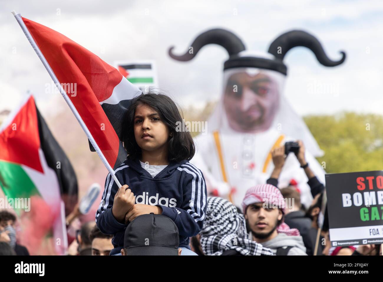 Young girl with Palestinian flag and inflatable demonic figure behind, Free Palestine Protest, Hyde Park, London, 22 May 2021 Stock Photo