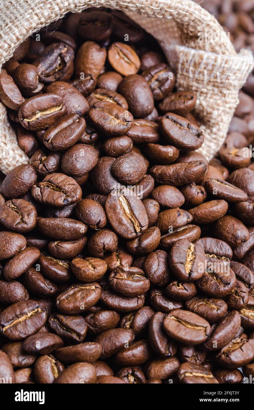 Coffee beans in sack bag on coffee beans background Stock Photo - Alamy