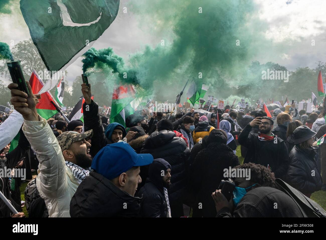 Crowd of protesters with smoke bombs and Palestinian flags under stormy sky, Free Palestine Protest, London, 22 May 2021 Stock Photo