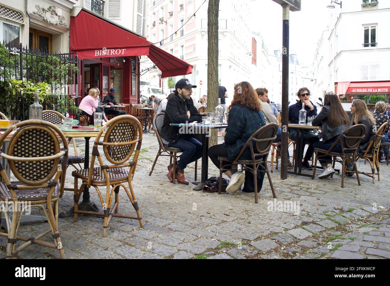 Parisians enjoy a drink on a Bistrot terrace, one of many terraces now open to the public after Covid-19 lockdown restrictions are eased -  Place Paul Albert, 75018, Paris, France. May 2021. Stock Photo