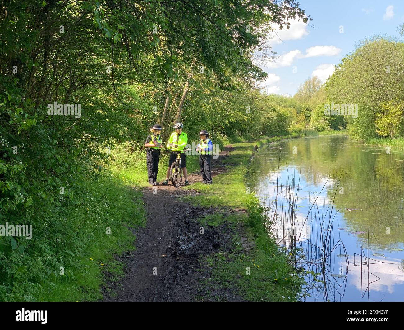 Officers speak to a passer-by about an incident that occurred in Rough Wood country park in Walsall, where a dead newborn baby boy was found in the local canal. Picture date: Thursday May 27, 2021. Stock Photo