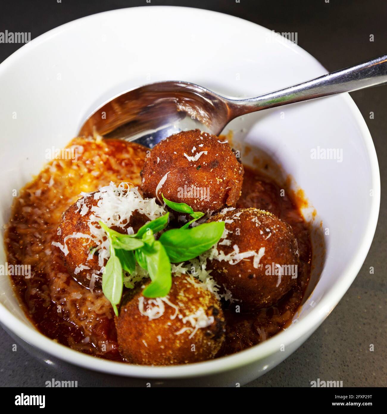 Arancini in tomato sauce. The dish is a popular example of Italian cuisine. Stock Photo