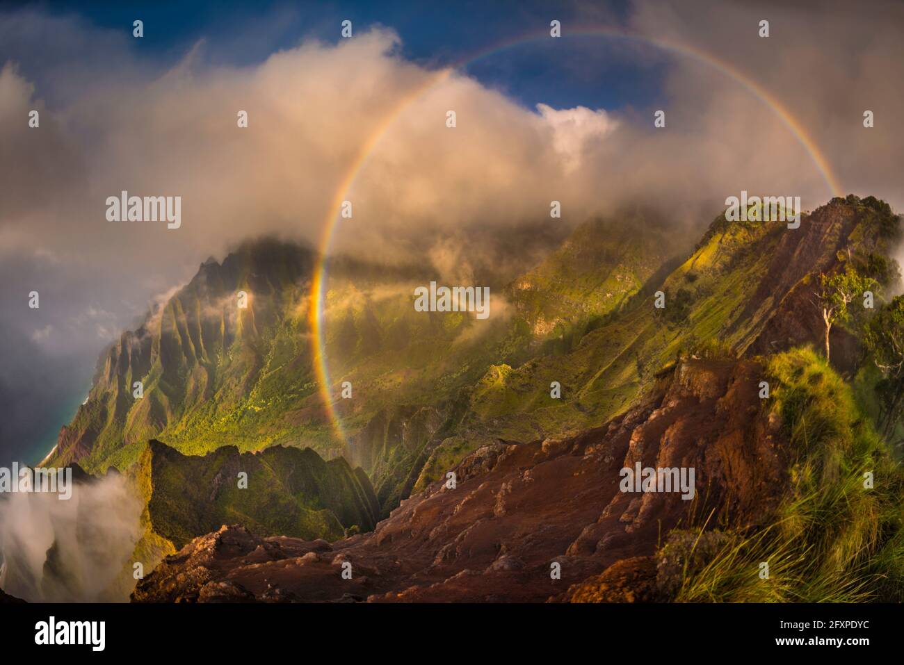 A 180 degree rainbow formed by the clouds over the Kalalau Valley in the evening, Napali Coast State Wilderness Park, Kauai, Hawaii, USA, Pacific Stock Photo