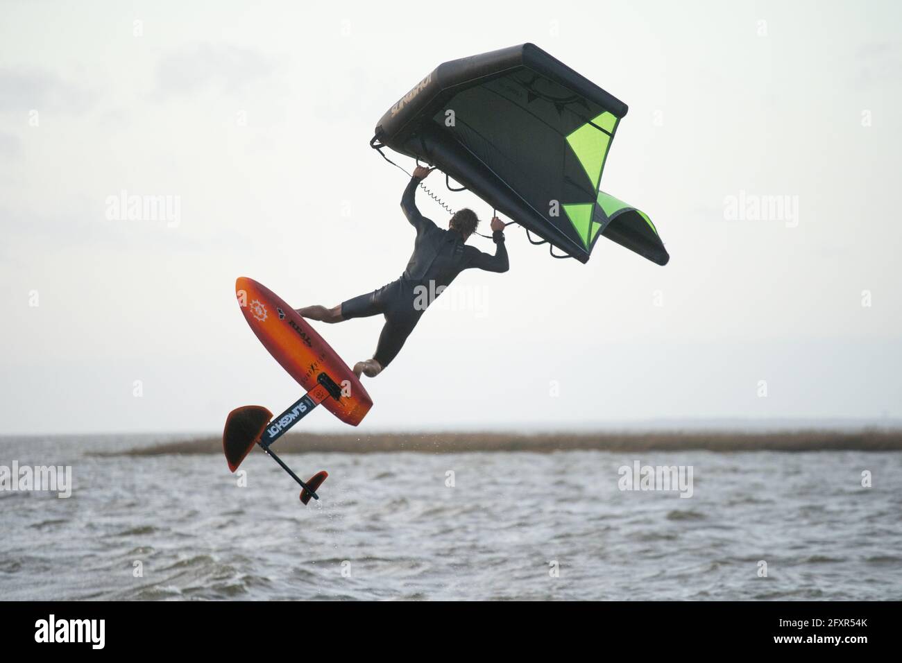 Pro surfer James Jenkins jumps his wing surfer over the Pamlico Sound at Nags Head, North Carolina, United States of America, North America Stock Photo
