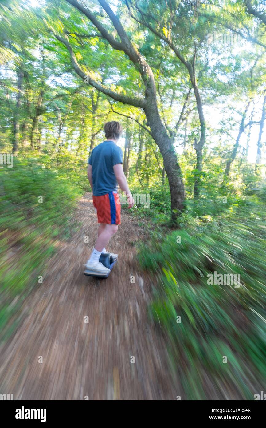 Christopher Brown rides his One-Wheel through a maritime forest near Nags Head, North Carolina, United States of America, North America Stock Photo