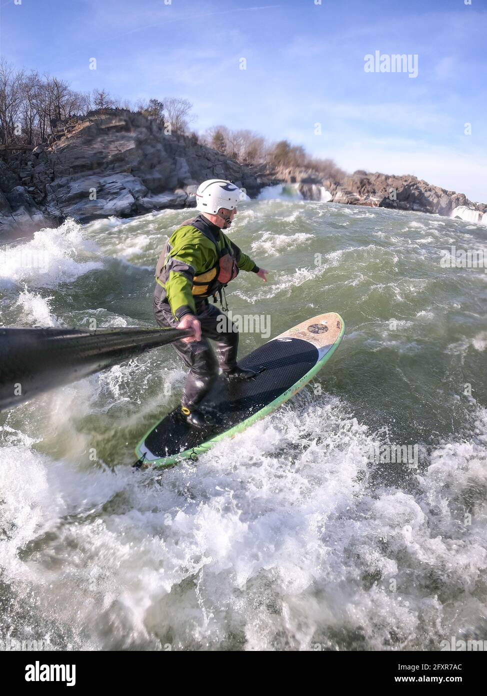 Photographer Skip Brown stand up paddle surfs in winter challenging whitewater below Great Falls of the Potomac River, USA Stock Photo