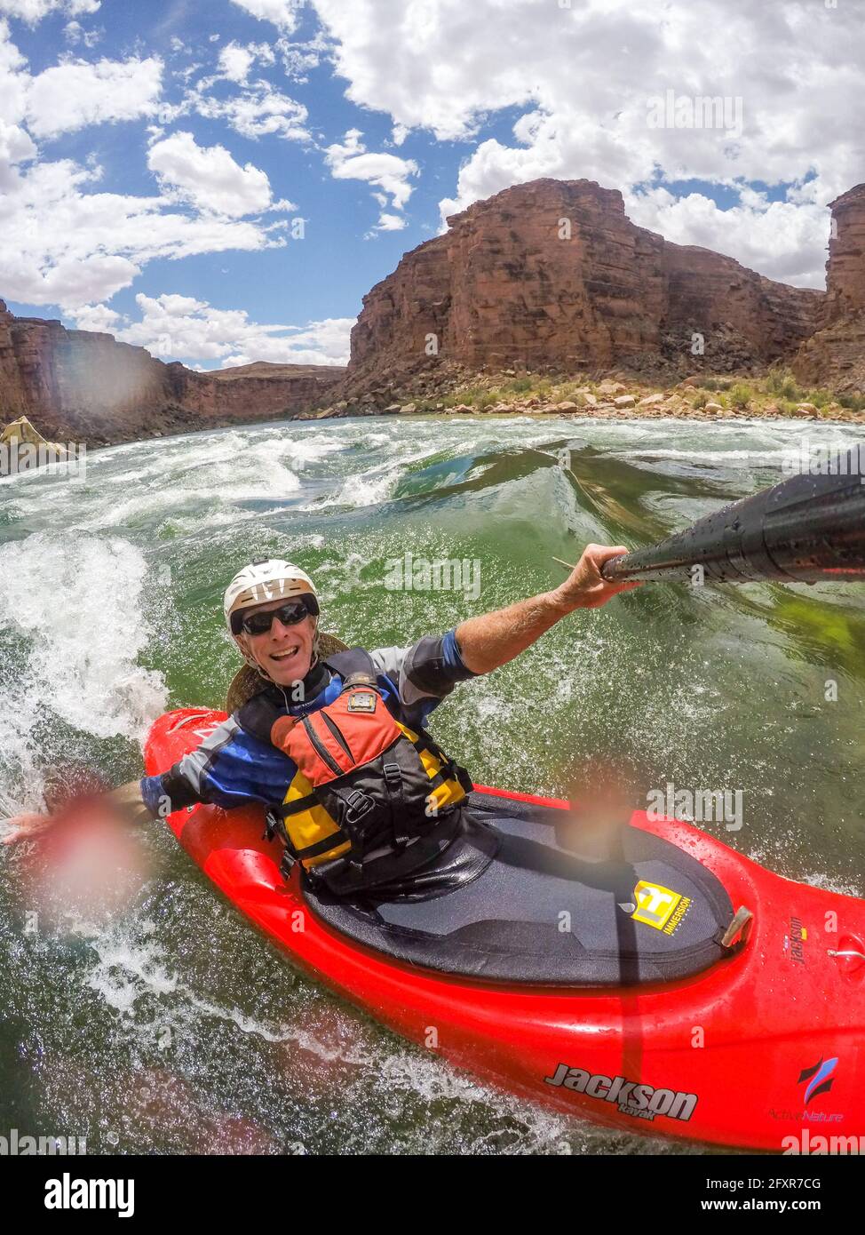 Skip Brown surfs his whitewater kayak on a glassy standing wave on the Colorado River through the Grand Canyon, Arizona, USA, North America Stock Photo