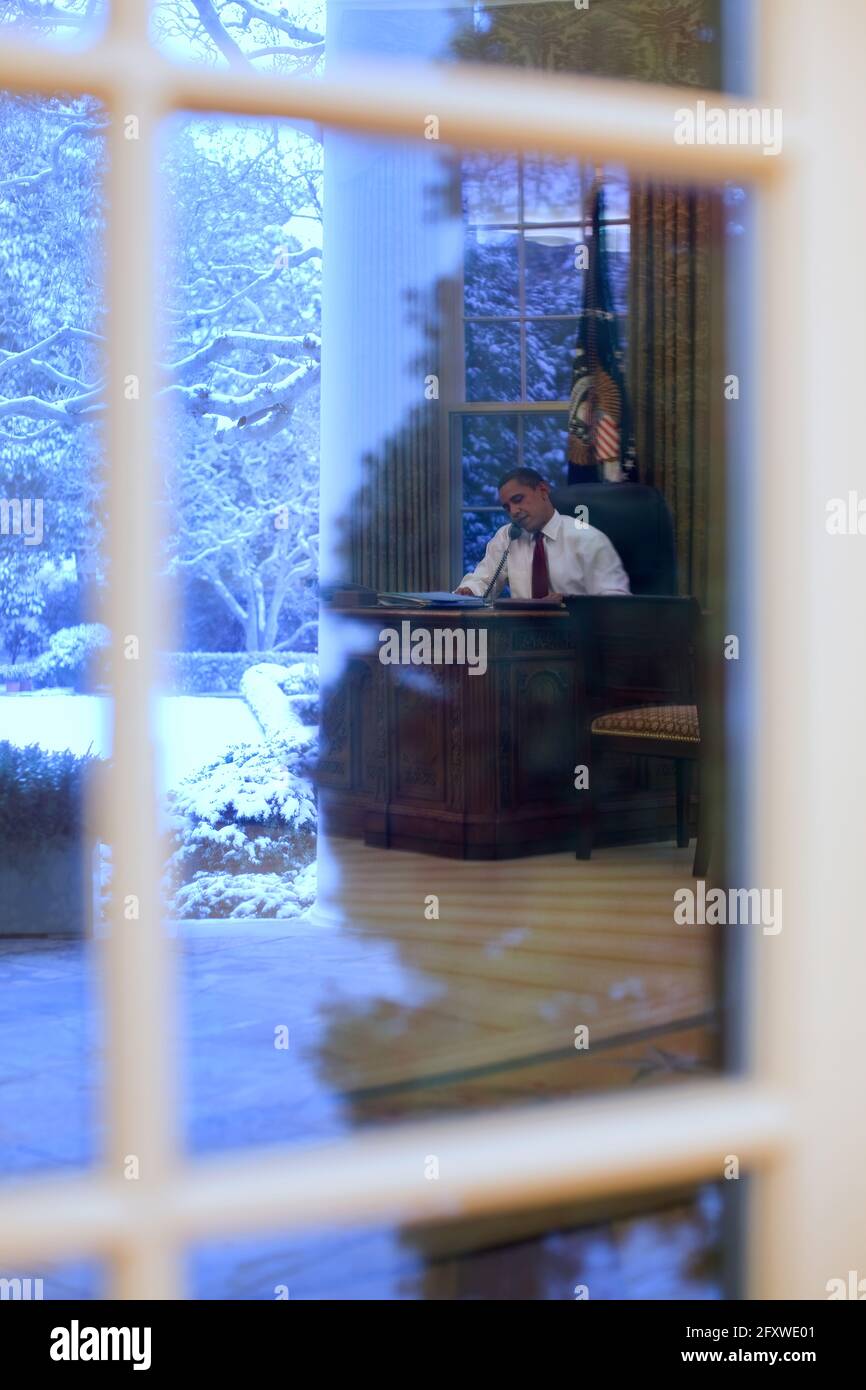 President Barack Obama talks on the phone in the Oval Office 1/27/09.Official White House Photo by Pete Souza Stock Photo
