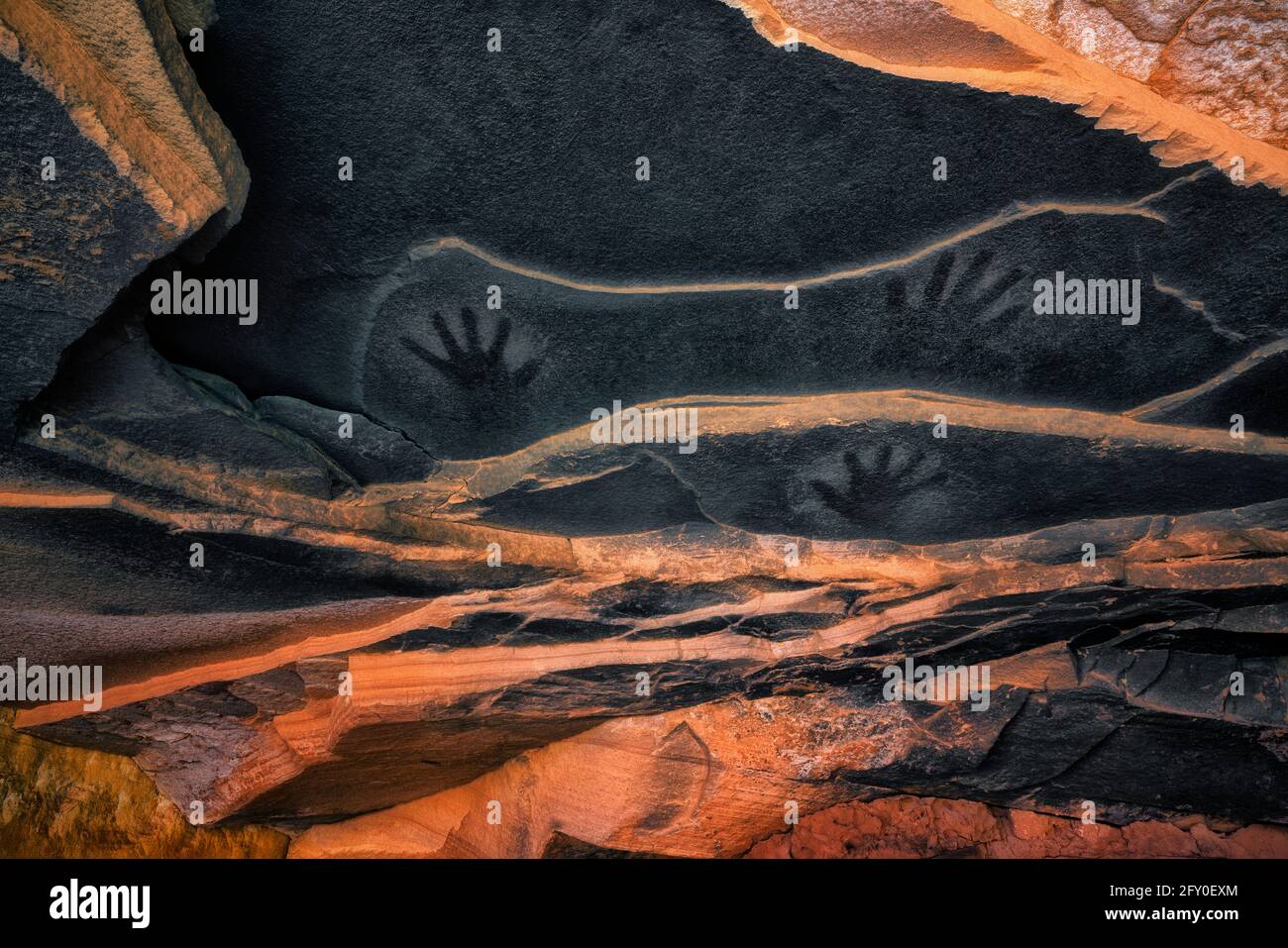 Ancient pictograph hand prints on the sandstone ceiling above the Anasazi Fallen Roof Ruin in SE Utah’s Cedar Mesa Plateau. Stock Photo