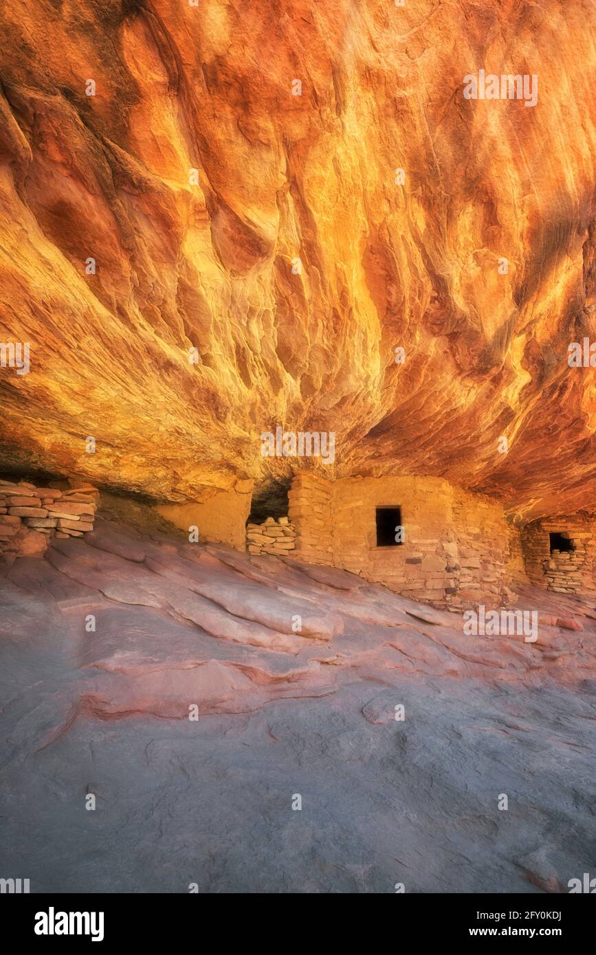 Reflective sunlight illuminates the sandstone rock above of this ancient Anasazi Granary and aptly named House on Fire Ruin in SE Utah’s Cedar Mesa Pl Stock Photo