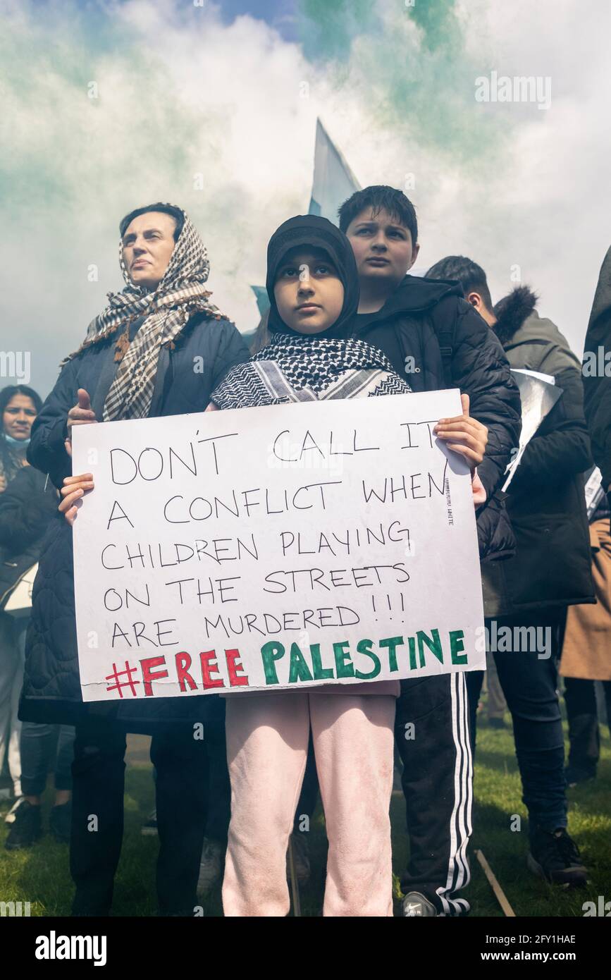A young girl holding a placard surrounded by smoke, Free Palestine Protest, Hyde Park, London, 22 May 2021 Stock Photo