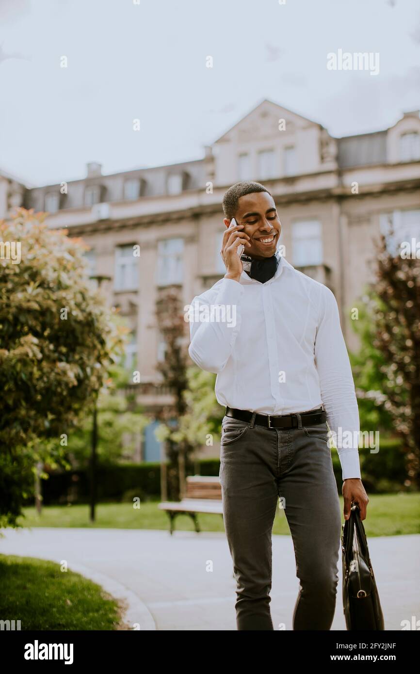 Handsome young African American businessman using a mobile phone on a street Stock Photo