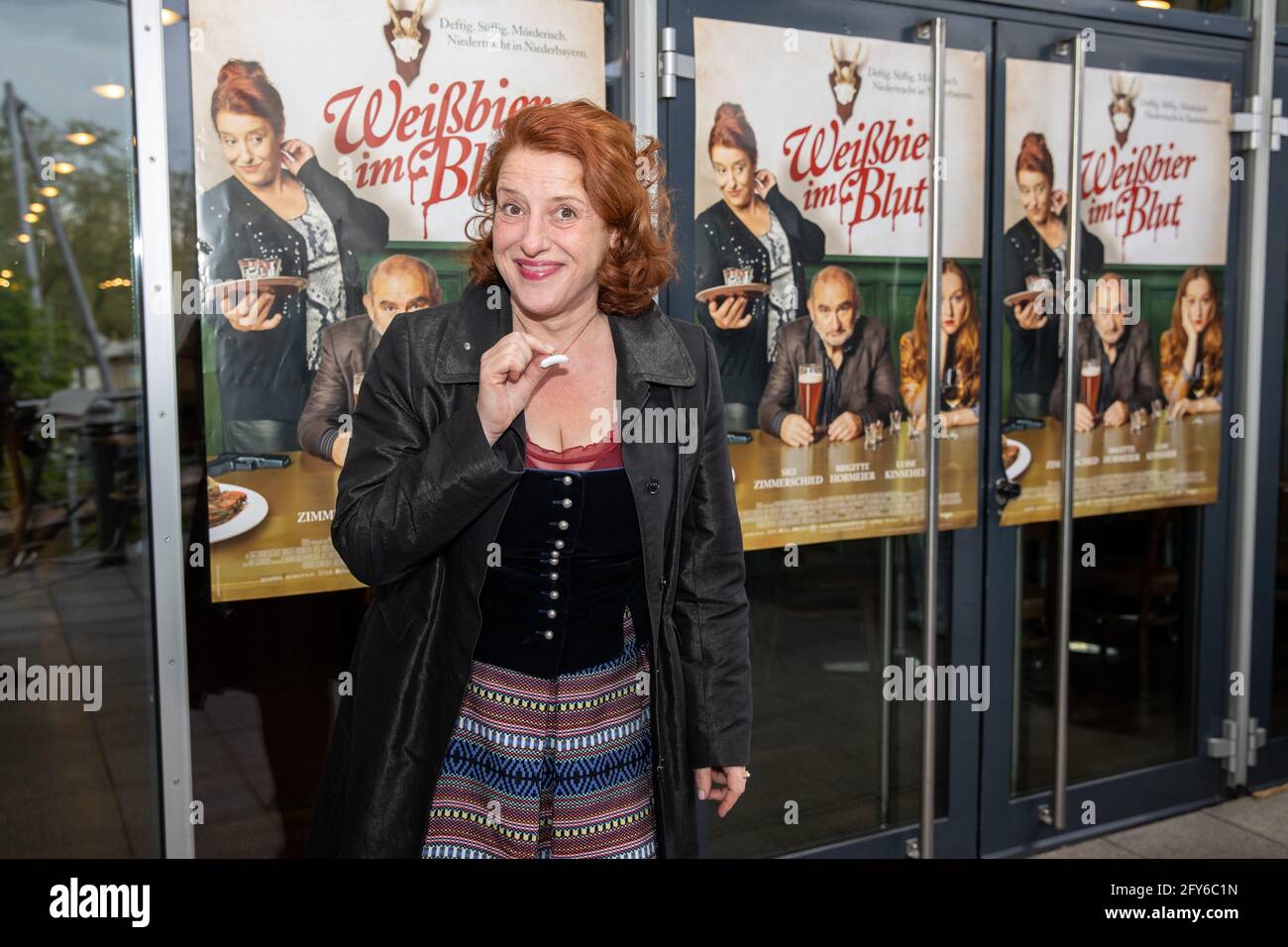 Nuremberg, Germany. 27th May, 2021. Actress Luise Kinseher arrives at the premiere of the film 'Weißbier im Blut' at the Cinecitta Nuremberg and shows her necklace with a Weißwurst. Credit: Daniel Karmann/dpa/Alamy Live News Stock Photo