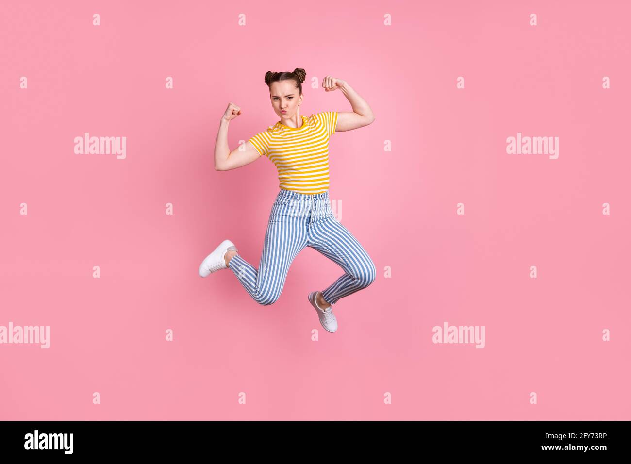 Full size portrait of energetic young person jumping flexing biceps isolated on pink color background Stock Photo
