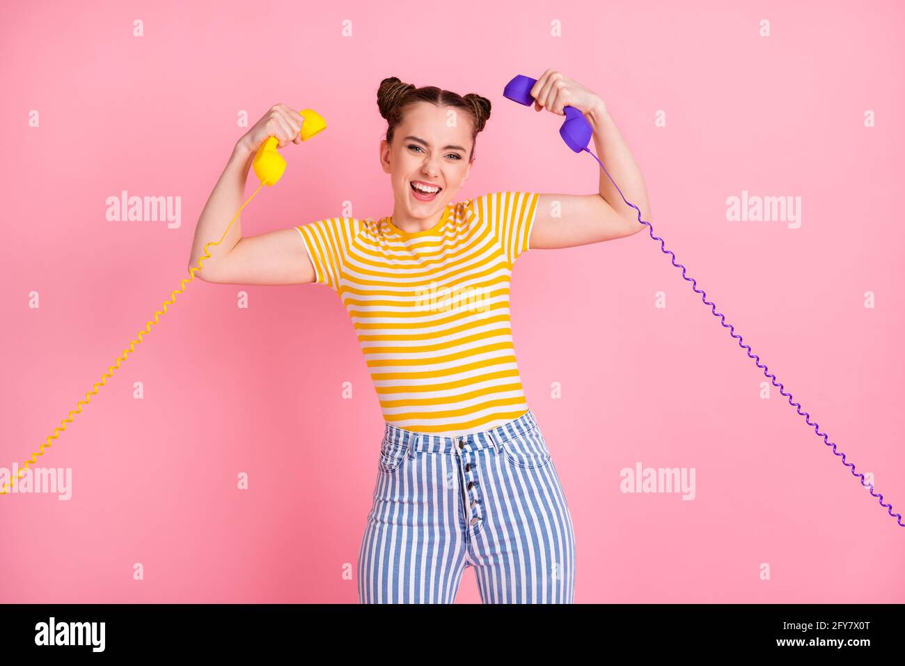 Photo of funny girl hands hold vintage handset flexing biceps have fun isolated on pink color background Stock Photo