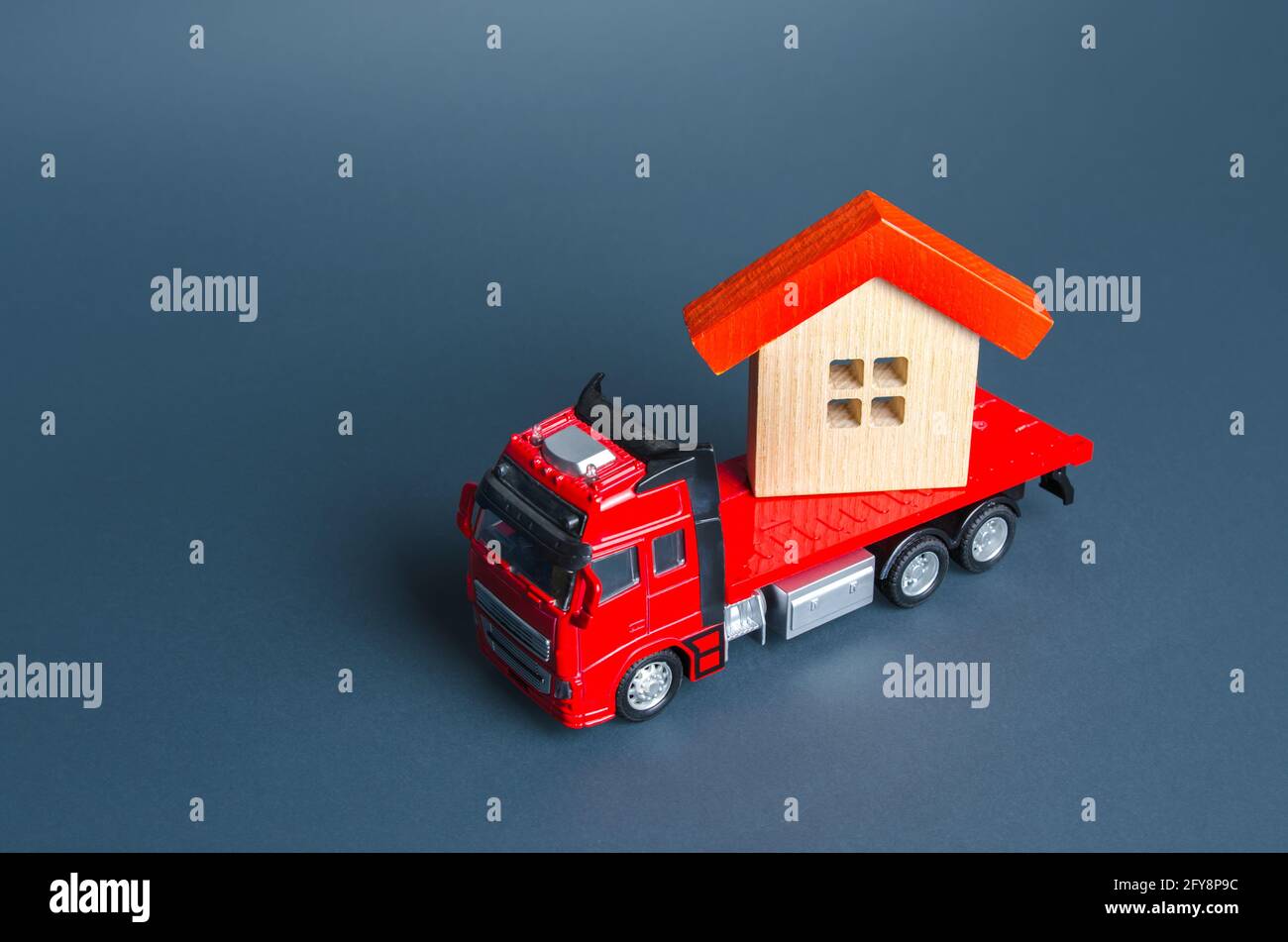 Truck transporting a house. Delivery services to another house. A moving company. Transportation of real estate. Resettlement program for new housing. Stock Photo