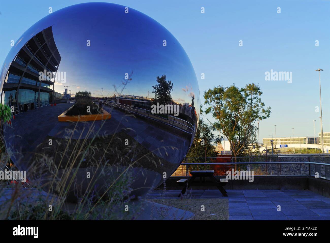 DUBLIN, IRELAND - Oct 27, 2019: A spherical stainless steel art installation reflects the surroundings of the Port Centre building in Dublin, Ireland. Stock Photo