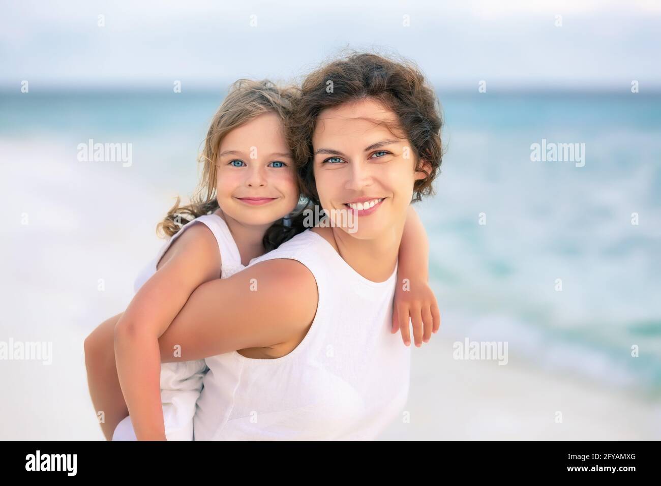 Portrait of happy mother and little daughter on ocean beach on Maldives at summer vacation. Family on the beach concept. Stock Photo