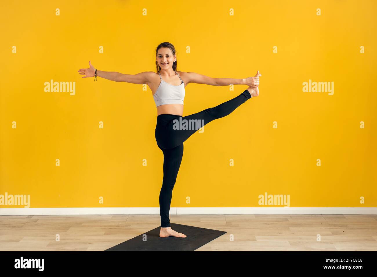 Vertical Portrait of Peaceful Young Woman in White Sportswear Balancing on  One Leg with Raised Arm in Tree Pose Relaxing Stock Image - Image of  female, eyes: 283081633