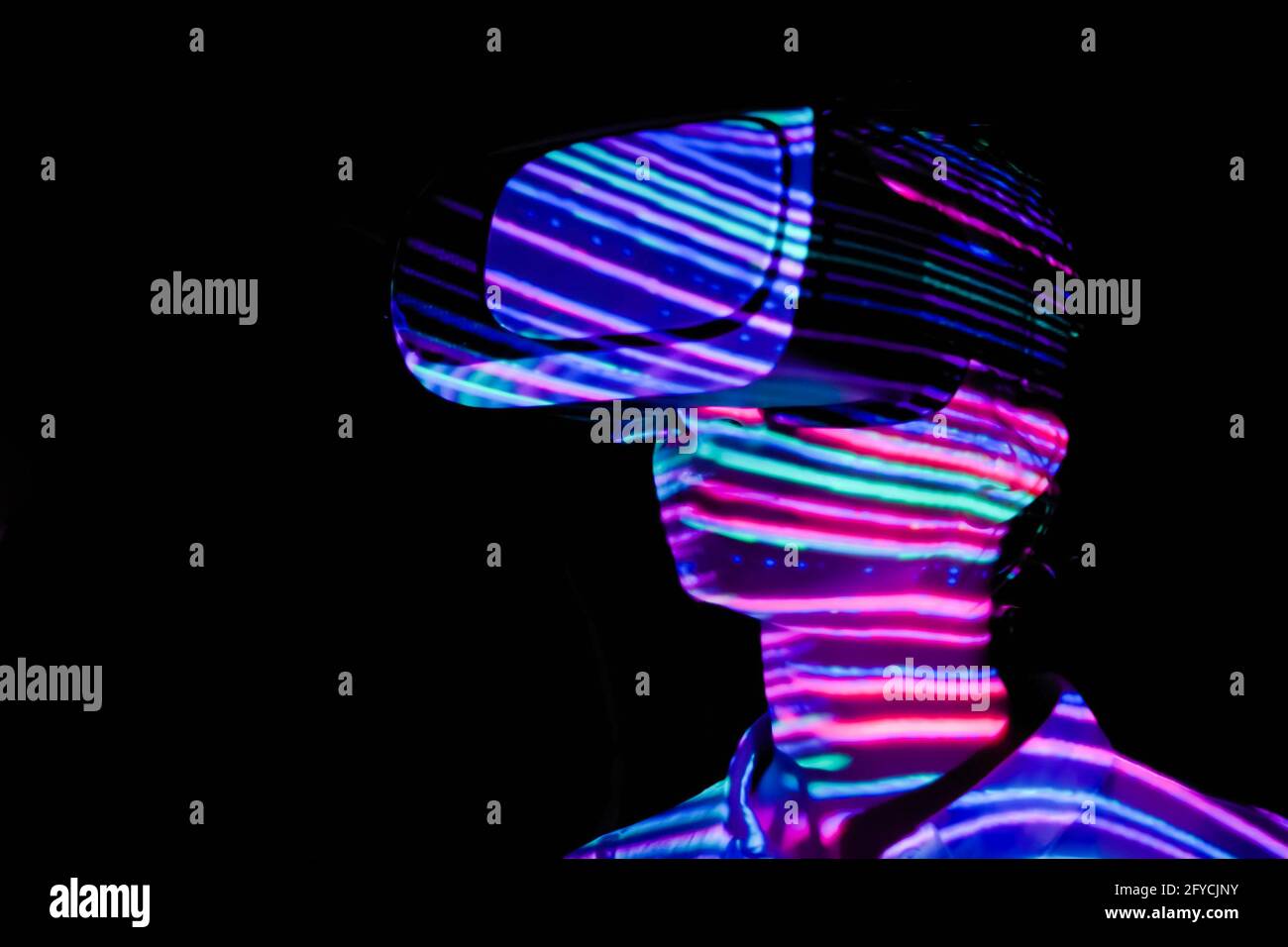 Young woman using virtual reality headset at dark interactive VR exhibition Stock Photo