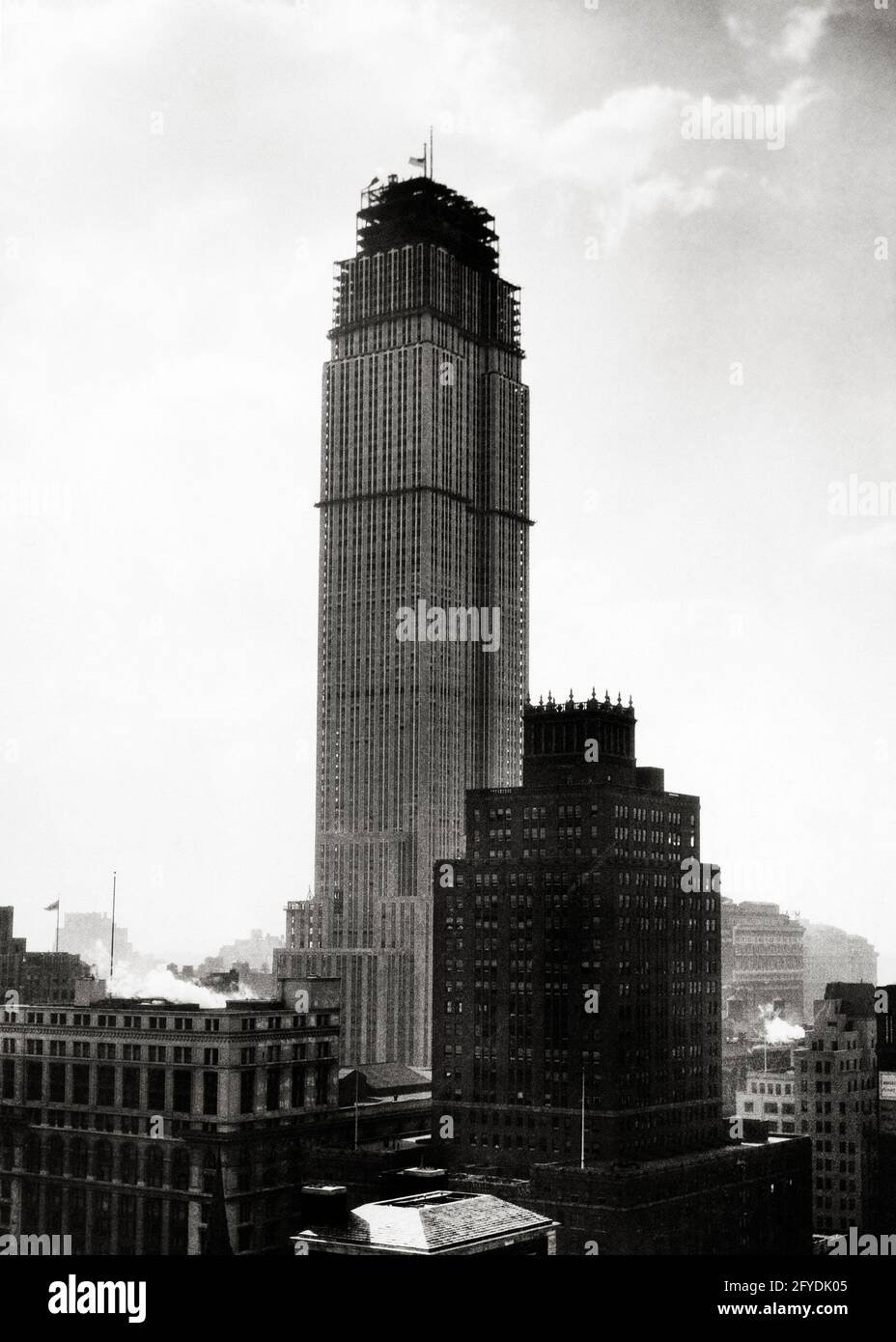 1930s NEARING COMPLETION EMPIRE STATE BUILDING UNDER CONSTRUCTION MANHATTAN FIFTH AVENUE NEW YORK CITY USA  - q74956 CPC001 HARS NYC UNFINISHED REAL ESTATE NEW YORK STRUCTURES CITIES COMPLETED EDIFICE NEARLY NEW YORK CITY COMPLETION NEARING SYMBOLIC CREATIVITY NATIONAL HISTORIC LANDMARK SKYSCRAPER TOURIST ATTRACTION ART DECO BLACK AND WHITE EMPIRE STATE BUILDING FIFTH AVENUE ICONIC LANDMARK OLD FASHIONED Stock Photo
