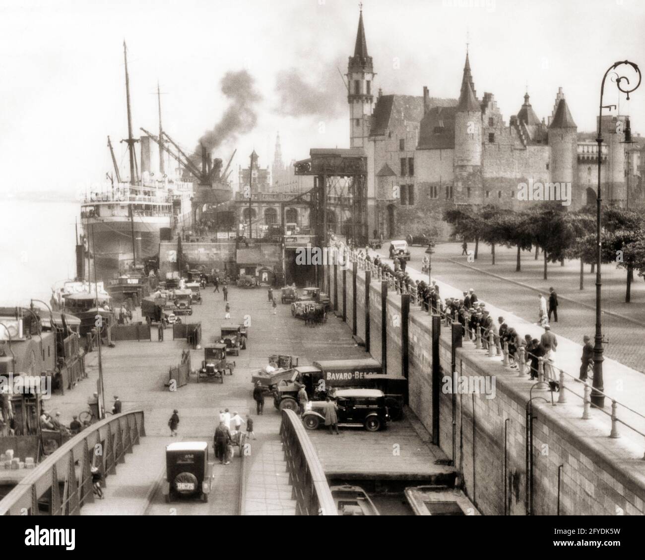 1920s 1928 SHIPPING ACTIVITY ON RIVER SCHELDT WATERFRONT & THE HET STEEN A MEDIEVAL FORTRESS IN THE OLD CITY OF ANTWERP BELGIUM - r4476 HAR001 HARS TRANSPORT COPY SPACE LADIES PERSONS AUTOMOBILE MALES BUILDINGS PEDESTRIANS TRANSPORTATION CARGO EUROPE B&W BELGIUM ACTIVITY PEDESTRIAN STRUCTURE HIGH ANGLE EUROPEAN PROPERTY AUTOS EXCITEMENT EXTERIOR REAL ESTATE AUTOMOBILES VEHICLES EDIFICE FORTRESS FREIGHTER TRADE COMMERCE SHIPPING WATERFRONT 1928 BLACK AND WHITE HAR001 OLD FASHIONED OLDEST VESSEL Stock Photo