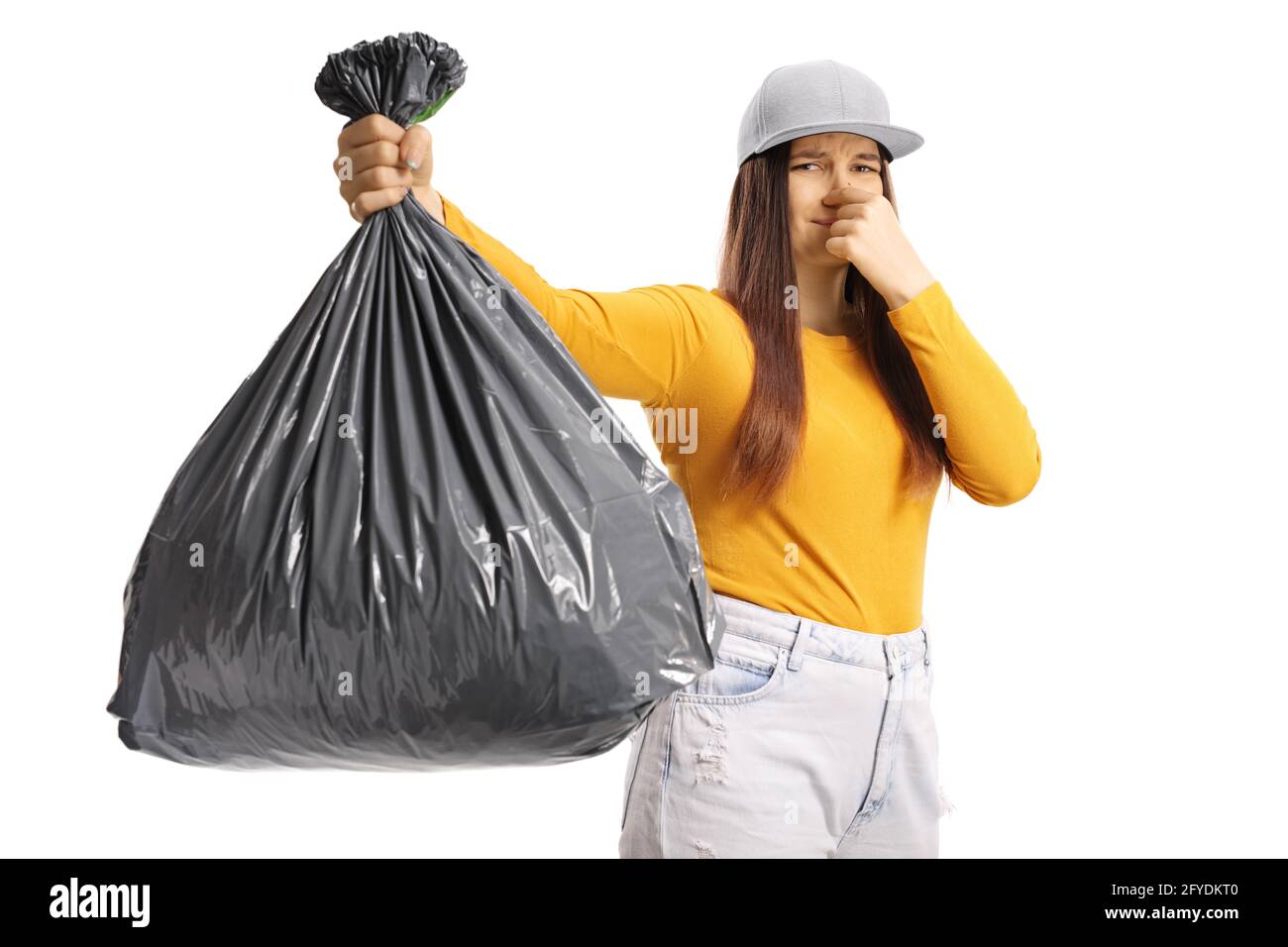 Young female holding a smelly bin bag isolated on white background Stock Photo