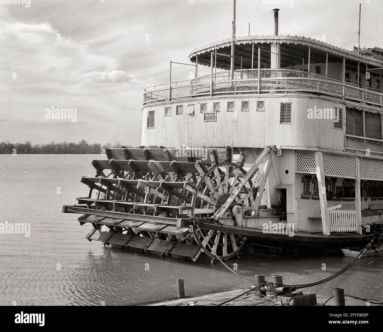 1930s 1940s PADDLE WHEEL PASSENGER PACKET RIVER BOAT TIED TO SHORE ON MISSISSIPPI RIVER ALTON ILLINOIS USA - s7266 HAR001 HARS STYLISH RIVERBOAT BLACK AND WHITE HAR001 IL MISSISSIPPI OLD FASHIONED PACKET STEAMBOAT Stock Photo