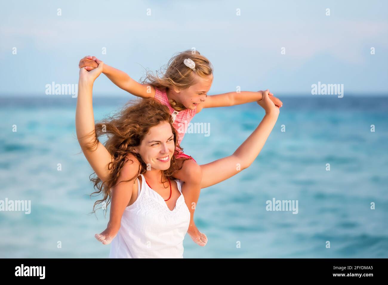 Happy mother and daughter on the ocean beach on Maldives at summer vacation Stock Photo