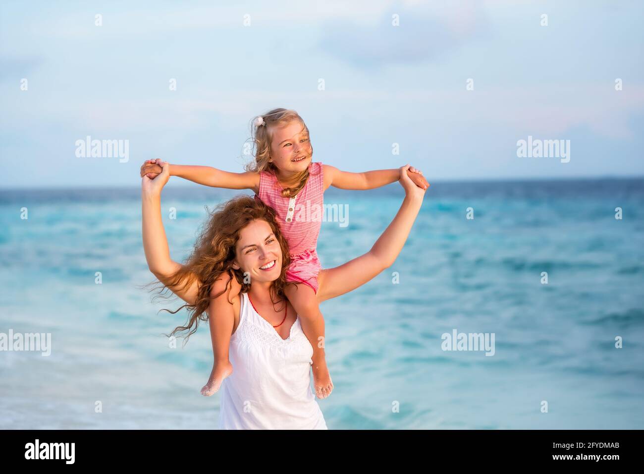 Happy mother and daughter on the ocean beach on Maldives at summer vacation Stock Photo