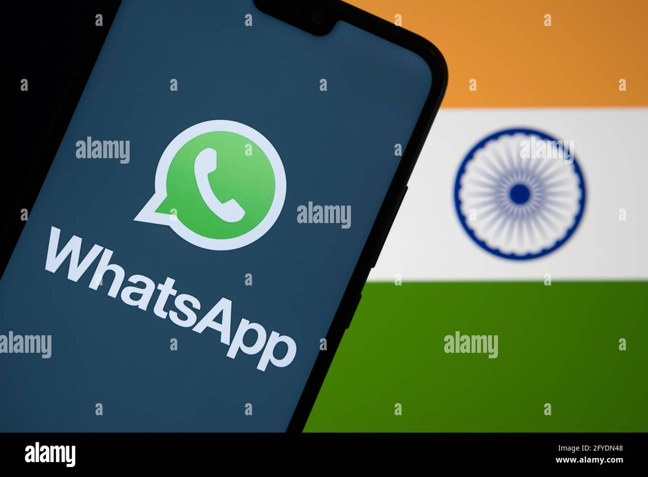 WhatsApp logo seen on smartphone screen and flag of India on the blurred background. Concept. Stafford, United Kingdom, May 27, 2021. Stock Photo