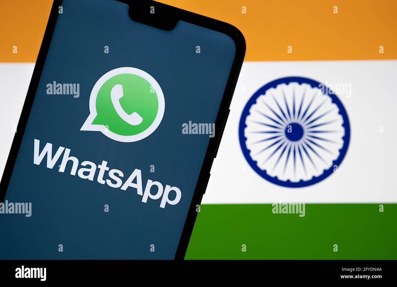 WhatsApp logo seen on smartphone screen and flag of India on the blurred background. Concept. Stafford, United Kingdom, May 27, 2021. Stock Photo