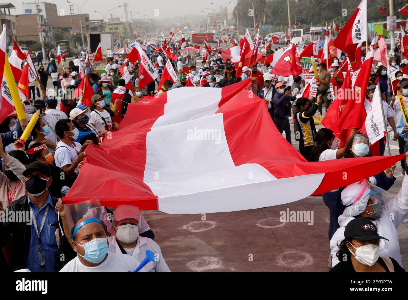 Lima, Peru. 26th May, 2021. People holding a Peruvian flag attend a campaign rally for Presidential candidate Pedro Castillo, in Villa El Salvador neighborhood. On June 6 Peruvians will go to the polls to elect new President between Castillo and Keiko Fujimori. Credit: Mariana Bazo/ZUMA Wire/Alamy Live News Stock Photo