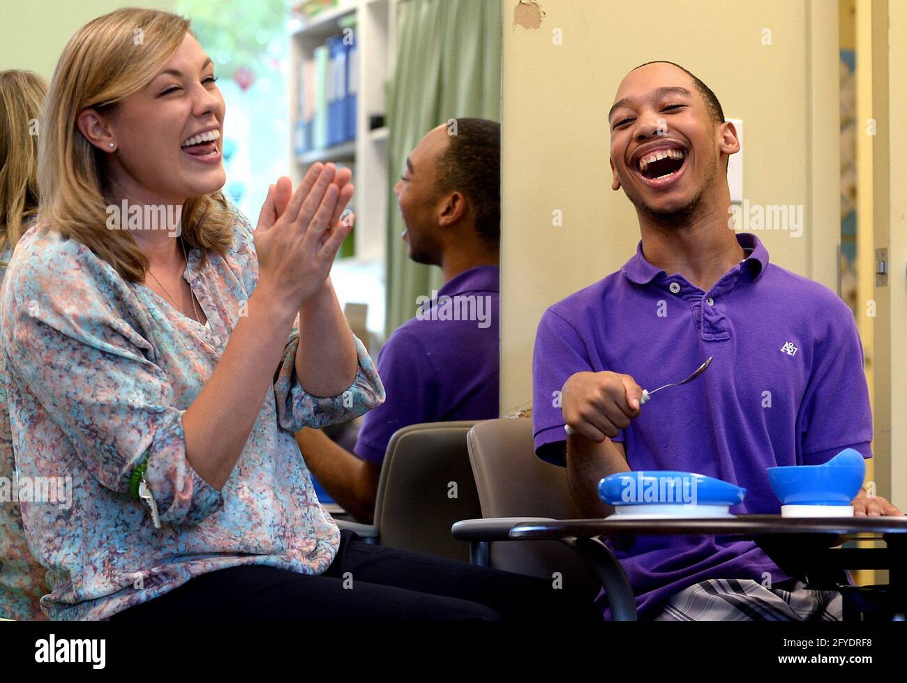 Charlotte, USA. 20th Sep, 2016. Chancellor Lee Adams, right, laughs with occupational therapist Abbey Wash, left, during an exercise where he uses a spoon to transfer contents from one bowl to another in September 2016. (Photo by Jeff Siner/Charlotte Observer/TNS/Sipa USA) Credit: Sipa USA/Alamy Live News Stock Photo
